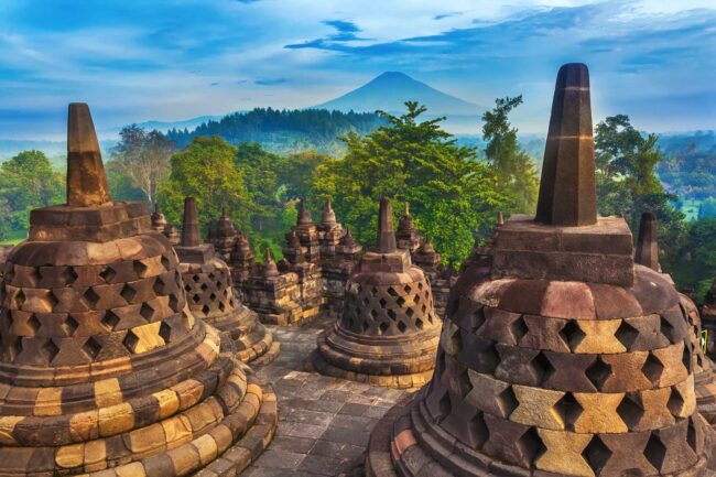 Candi Borobudur in the background of rainforest, morning mist and Sumbing Mountain. Yogyakarta, Jawa, Indonesia.